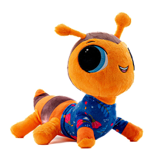 A musical plush toy, Averie Ant hums the lullaby Rock A Bye Baby. Averie Ant is pictured as a side view, it stands 9.5 inches tall from the bottom to the top of its antenna. Averie Ant a musical plushie is ultra soft and is orange and brown wearing a blue pajama top  with a floral pattern. Averie Ants face also lights up with a soft soothing glow.