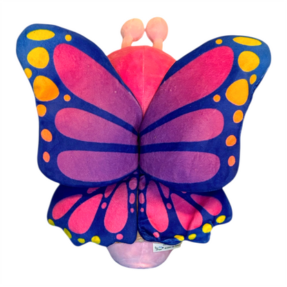 Butterfly-shaped pillow with pink center and blue and yellow wings on a white background