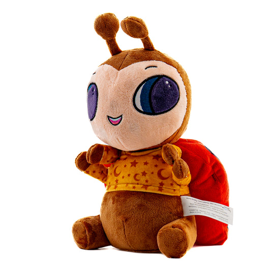 A musical plush toy, Lexie Ladybug hums the lullaby, Lullaby and Goodnight. Lexie Ladybug is pictured as a side view, it stands 12 inches tall from the bottom to the top of its antenna. Lexie Ladybug plushie is ultra soft and is shown in light brown, brown. with red and black wings wearing a light orange pajama top with stars and crescent moons. Lexie Ladybugs face also lights up with a soft soothing glow.